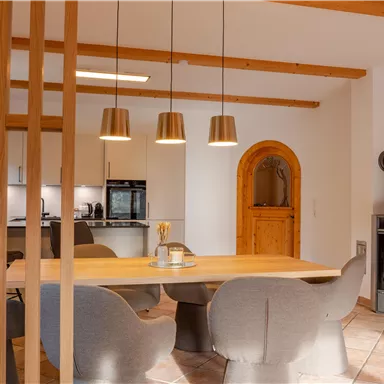 Eine moderne Küche mit einem Essbereich und stilvollen Stühlen. In der Ecke steht ein gemütlicher Kamin.