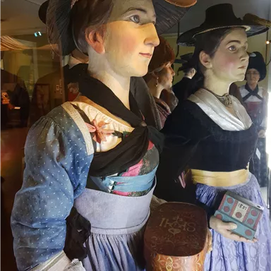 An exhibition with two historical figures in traditional clothing. The figures appear lively and are presented in a museum theme.