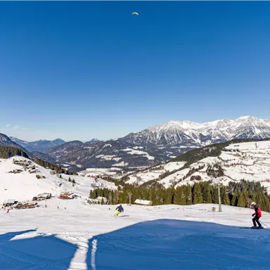 A picturesque ski resort with snow-covered mountains and blue skies. Skiers enjoy the winter landscape.