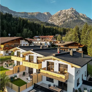 Modern chalets in a picturesque mountain landscape. The surroundings are surrounded by trees and majestic mountains.