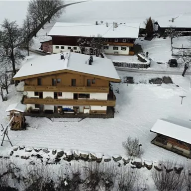 A cozy wooden house in a snowy landscape. Surrounded by snow-covered trees and a peaceful winter environment.