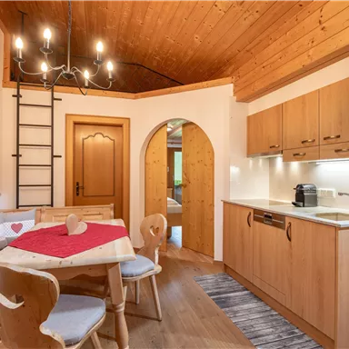 Eine gemütliche Küche mit Holzdekor und einem Essbereich. Der Raum ist hell und einladend, mit einem warmen Ambiente.