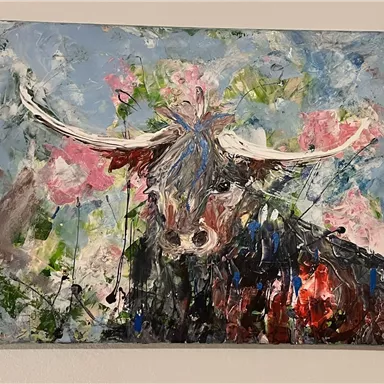 Ein kreatives Gemälde eines Viehs mit langen Hörnern. Im Hintergrund sind farbige Blumen und ein blauer Himmel zu erkennen.