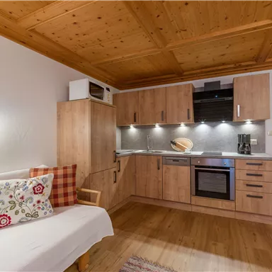 A modern kitchen with wooden surfaces and practical appliances. The space is designed to be bright and cozy.