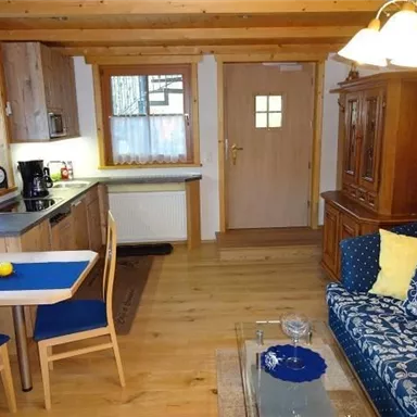 Eine gemütliche Ferienwohnung mit einer modernen Küche und einem einladenden Wohnbereich. Der Raum ist hell erleuchtet und bietet eine komfortable Atmosphäre.