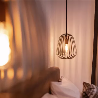 A cozy bedroom view with modern lamps. The warm lights create an inviting atmosphere.
