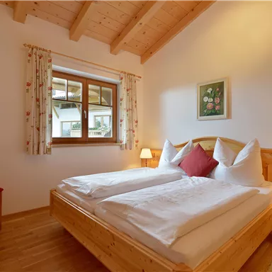 Ein gemütliches Schlafzimmer mit zwei Betten und Holzverarbeitung. Es gibt ein Fenster mit Blick nach draußen und eine angenehme Beleuchtung.