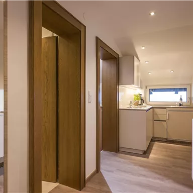 A modern kitchen environment with light wood and clean lines. The space is well-lit and feels inviting.