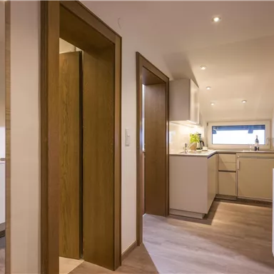 A modern kitchen environment with light wood and clean lines. The space is well-lit and feels inviting.