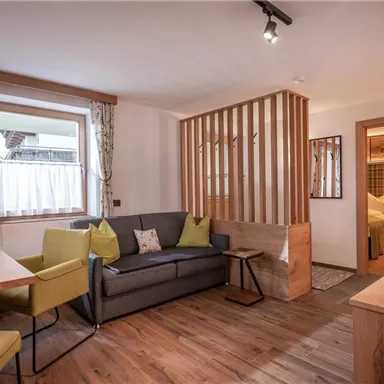 A cozy living area with a seating group and a dining table. Good lighting and wooden details create an inviting atmosphere.