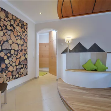 An inviting living space with ergonomic furniture and a charming wooden decor wall. The bright colors and clear design create a calm atmosphere.