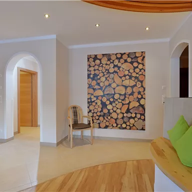 A modern room with lights and wooden details. On the wall hangs a large picture of stacked wood.