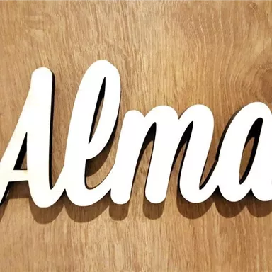 A white inscription with the word "Alma" on a wooden background. The inscription has an elegant, curved shape.