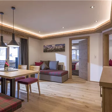 A modern apartment with a cozy dining area and stylish decor. Large windows provide plenty of light and an inviting atmosphere.