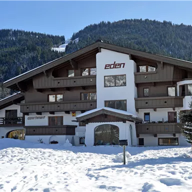 Ein schönes Gebäude im alpinen Stil, umgeben von Schnee und Bergen. Der Name "eden" ist gut sichtbar an der Fassade.