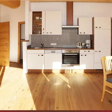 Eine helle und moderne Wohnung mit Holzverkleidung. Sie verfügt über eine offene Küche, einen Essbereich und komfortable Möbel.