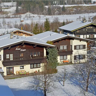 Snow-covered houses in a picturesque winter landscape. The surroundings are quiet and surrounded by trees.