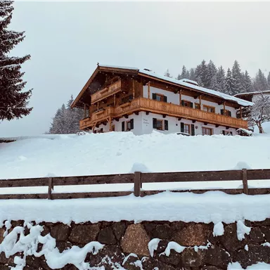 A charming chalet in the snow-covered winter forest. The surroundings are quiet and idyllic with a beautiful, snowy landscape.