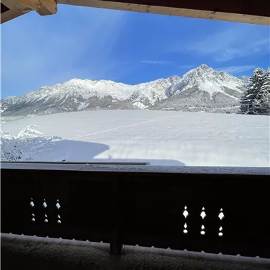 Schnee bedeckte Berge unter einem klaren blauen Himmel. Die Aussicht ist ruhig und winterlich.