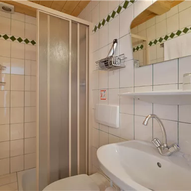 A bright bathroom with a shower and a sink. Tiles in neutral colors create a clean and elegant atmosphere.