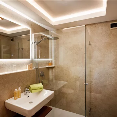 A modern bathroom with a glass shower and a stylish sink. Soft light and natural colors create a relaxing atmosphere.
