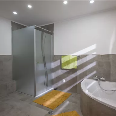 A modern bathroom with a shower and a freestanding bathtub. Bright colors and strategic lighting create an inviting atmosphere.