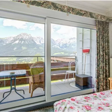 A cozy room with a view of the mountains. Large windows offer a magnificent view of the landscape.