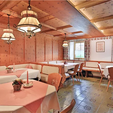 Ein gemütliches Restaurant mit Holzvertäfelung und warmem Licht. Die Tische sind ordentlich gedeckt und laden zum Verweilen ein.