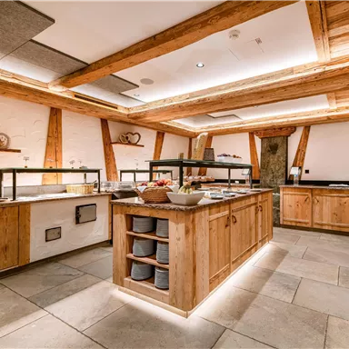 Eine gemütliche Küche mit Holzmöbeln und modernen Elementen. Die Theke ist mit verschiedenen Speisen schön dekoriert.