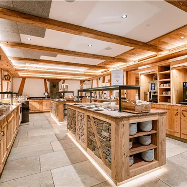 Ein modernes Küchen-Interieur mit Holzregalen und gut sortierten Ablagen. Das warme Licht schafft eine einladende Atmosphäre.