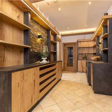 Ein moderner Innenraum mit Holzregalen und dunklen Akzenten. Der Raum hat eine einladende Atmosphäre mit warmem Licht.