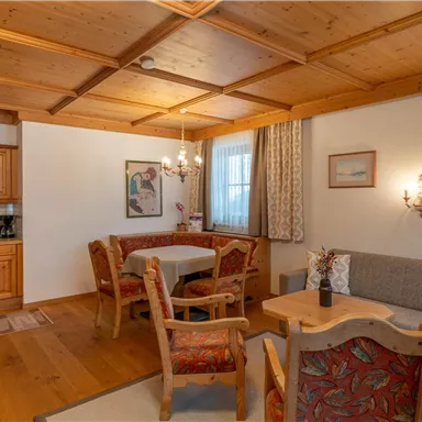 Ein gemütlicher Wohnraum mit einer modernen Küchenecke und einer Essgruppe. Helle Wände und ein entspannendes Holzdecke schaffen eine einladende Atmosphäre.