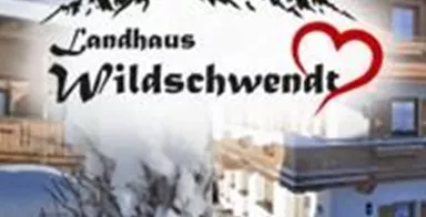 A cozy country house in a winter atmosphere with snow-covered mountains in the background. The inscription "Vacation in the Countryside" emphasizes the rural idyll.