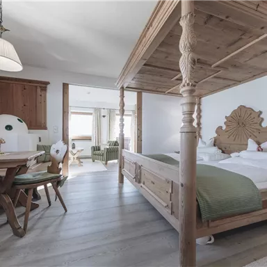 Ein gemütliches Zimmer mit einem Holz-Kinderbett und einem Esstisch. Der Raum ist hell und freundlich mit moderner Einrichtung.