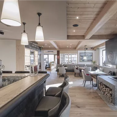 Ein modernes Restaurant mit einem einladenden Ambiente. Holzdecken und stilvolle Möbel schaffen eine gemütliche Atmosphäre.