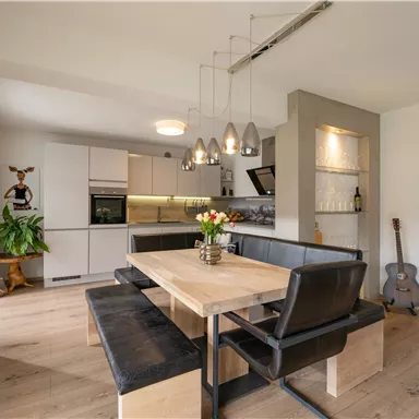 Moderne Küche mit einem Essbereich. Helle Farben und gemütliche Einrichtung schaffen eine einladende Atmosphäre.