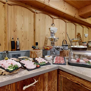 A buffet with various types of meat and fresh ingredients in a rustic setting. The wood look creates a cozy atmosphere.