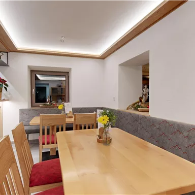 A cozy restaurant with wooden tables and benches. The soft lighting creates an inviting atmosphere.