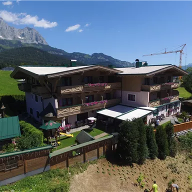 A charming building in the Alps with green meadows and mountains in the background. The atmosphere is calm and inviting.