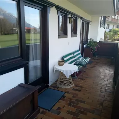 A beautiful balcony with a view of the landscape. There is a cozy seating area and plants that create an inviting atmosphere.