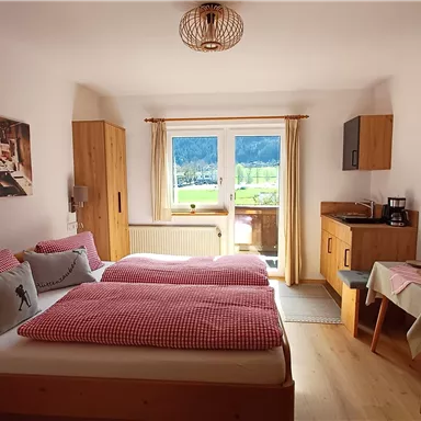 Ein gemütliches Zimmer mit zwei Einzelbetten und warmen Holzdetails. Das Fenster bietet einen schönen Blick auf die Landschaft.