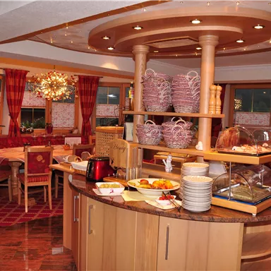 An inviting breakfast room with a round buffet and cozy seating. The warm colors and decorative ambiance create a pleasant atmosphere.