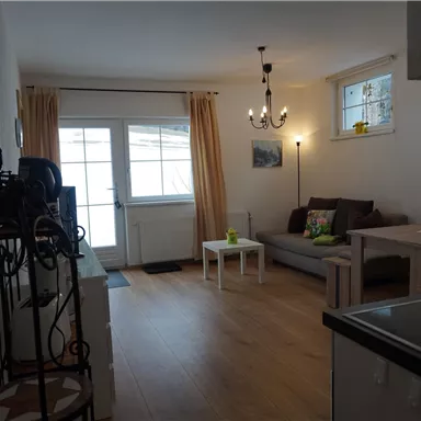 A bright living room with a cozy couch and a small table. Large windows let in plenty of light and create an inviting atmosphere.