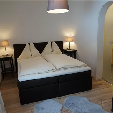 A cozy bedroom with a double bed and two nightstands. The room is bright and furnished in a modern style.