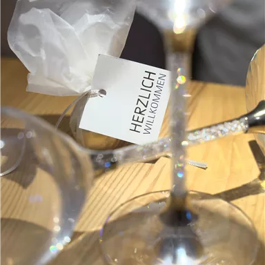 A table setting with glasses and a welcome sign. The atmosphere is inviting and elegant.