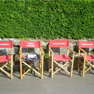 Four director's chairs with red seats are on the floor. Next to each chair is the inscription "Actor".