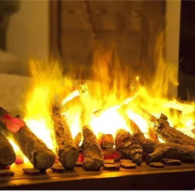 A cozy fireplace with blazing logs. The warm light creates a comfortable atmosphere.