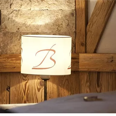 A soft illumination from a decorative lamp with an elegant design. The background consists of rustic wood and stone surfaces.