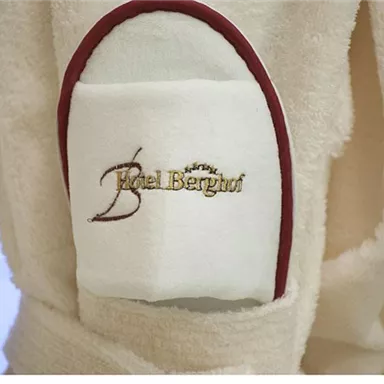 A soft bathrobe with a white pocket. On the pocket is the logo of the hotel "Hotel Barghut".
