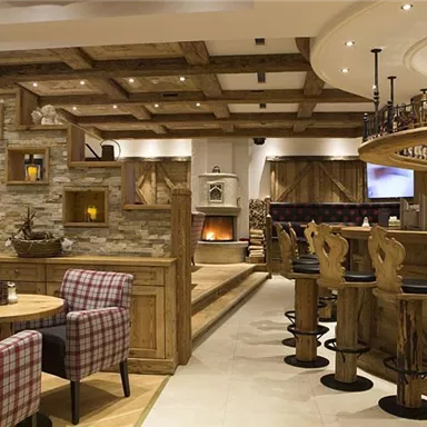 A cozy restaurant with wooden decor and an inviting bar. The space has a warm atmosphere with comfortable seating options.